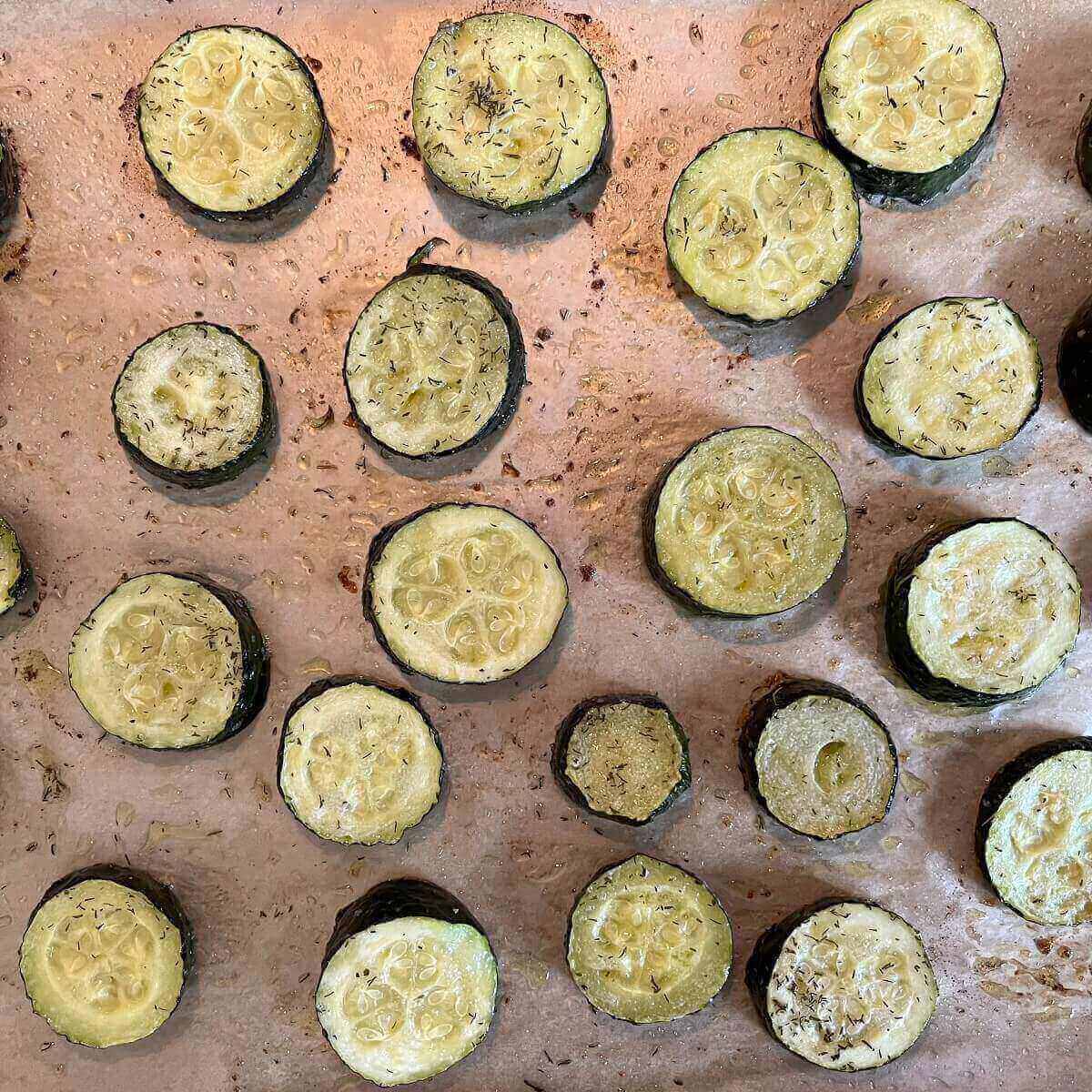 Bakes zucchini squash on a sheet pan lined with parchment paper.