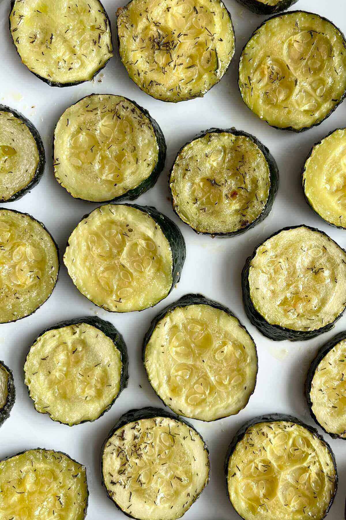 Slices of baked zucchini on a white plate.