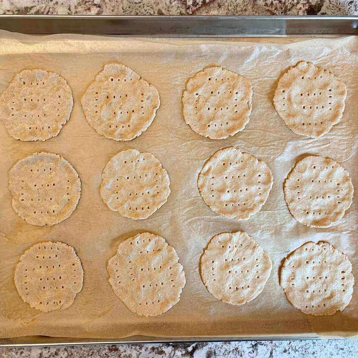 Raw crackers on a sheet pan lined with parchment paper.