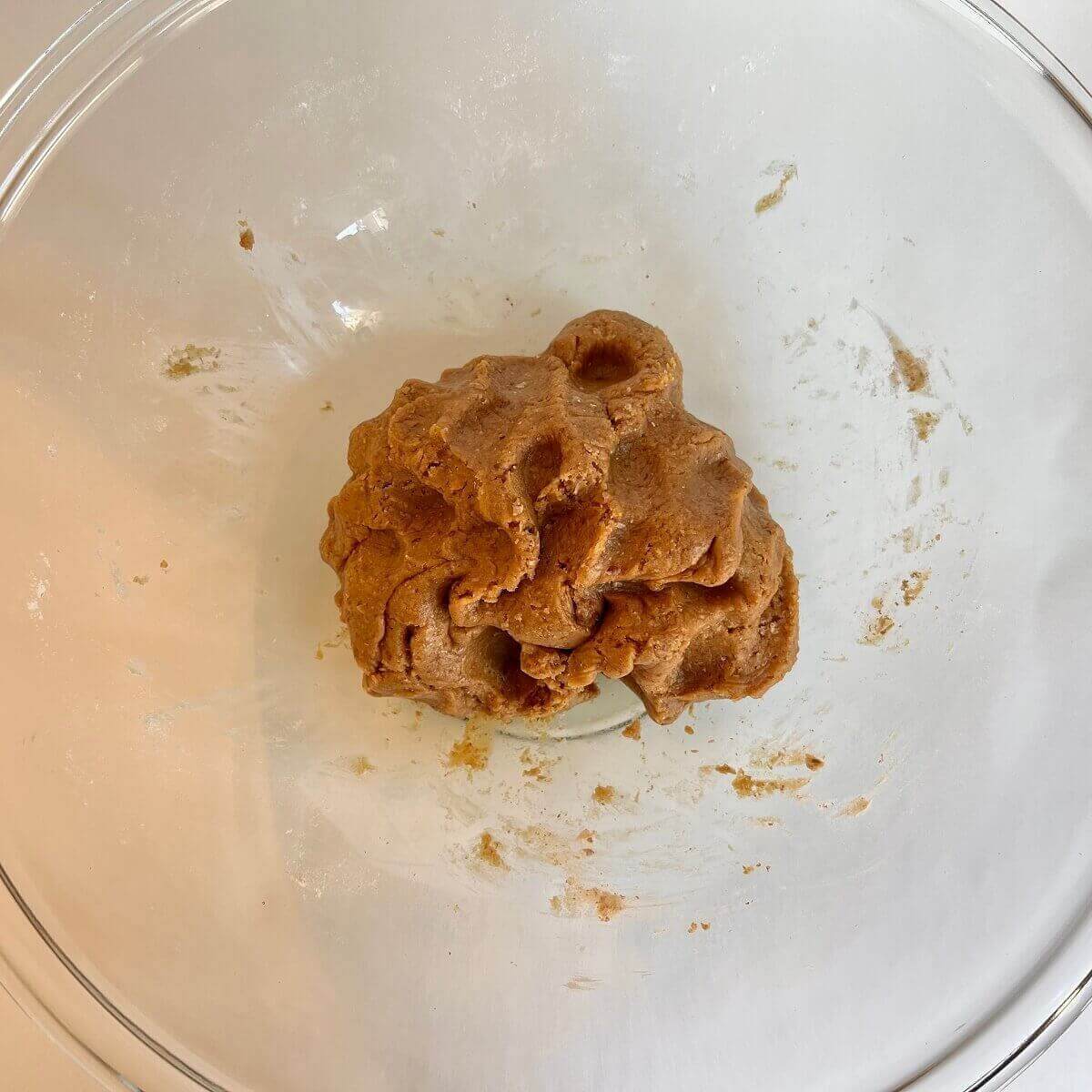 Raw peanut butter cookie dough in a glass bowl.