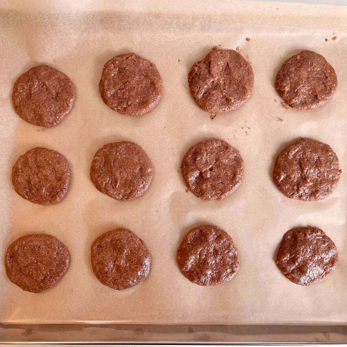 Raw strawberry cookies on a sheet pan lined with parchment paper.