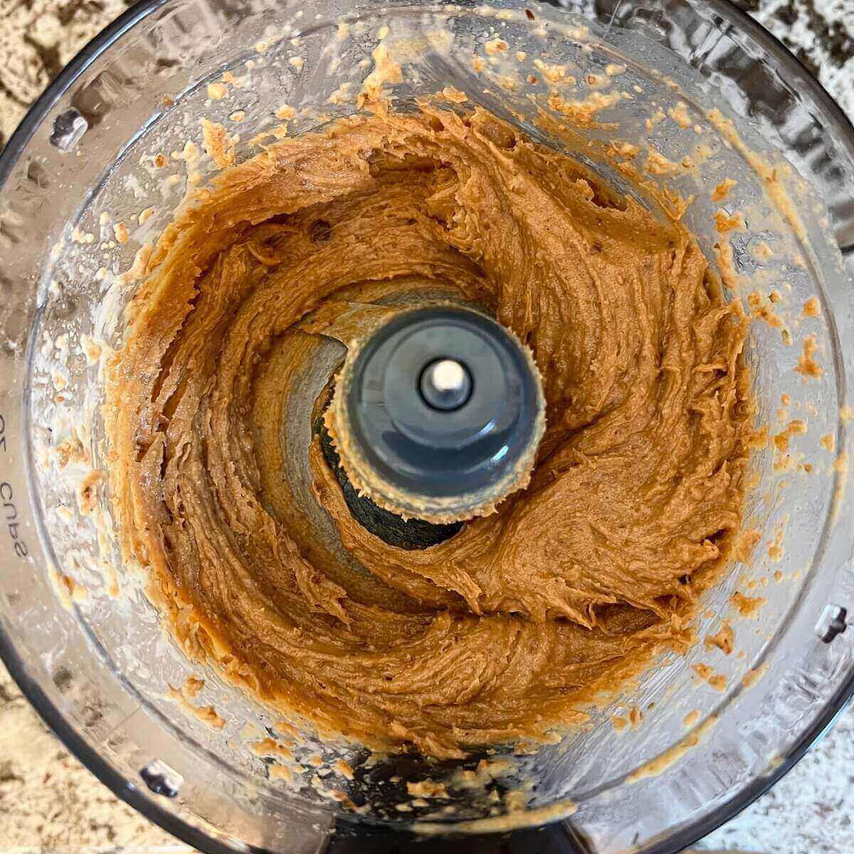 A light brown blended mixture in a food processor.