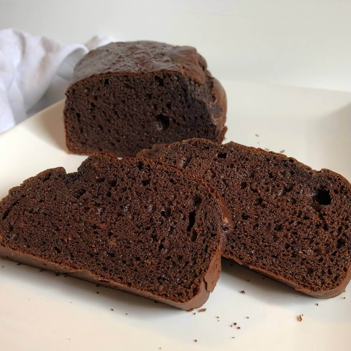 Gluten free bread on a white plate with two slices cut.