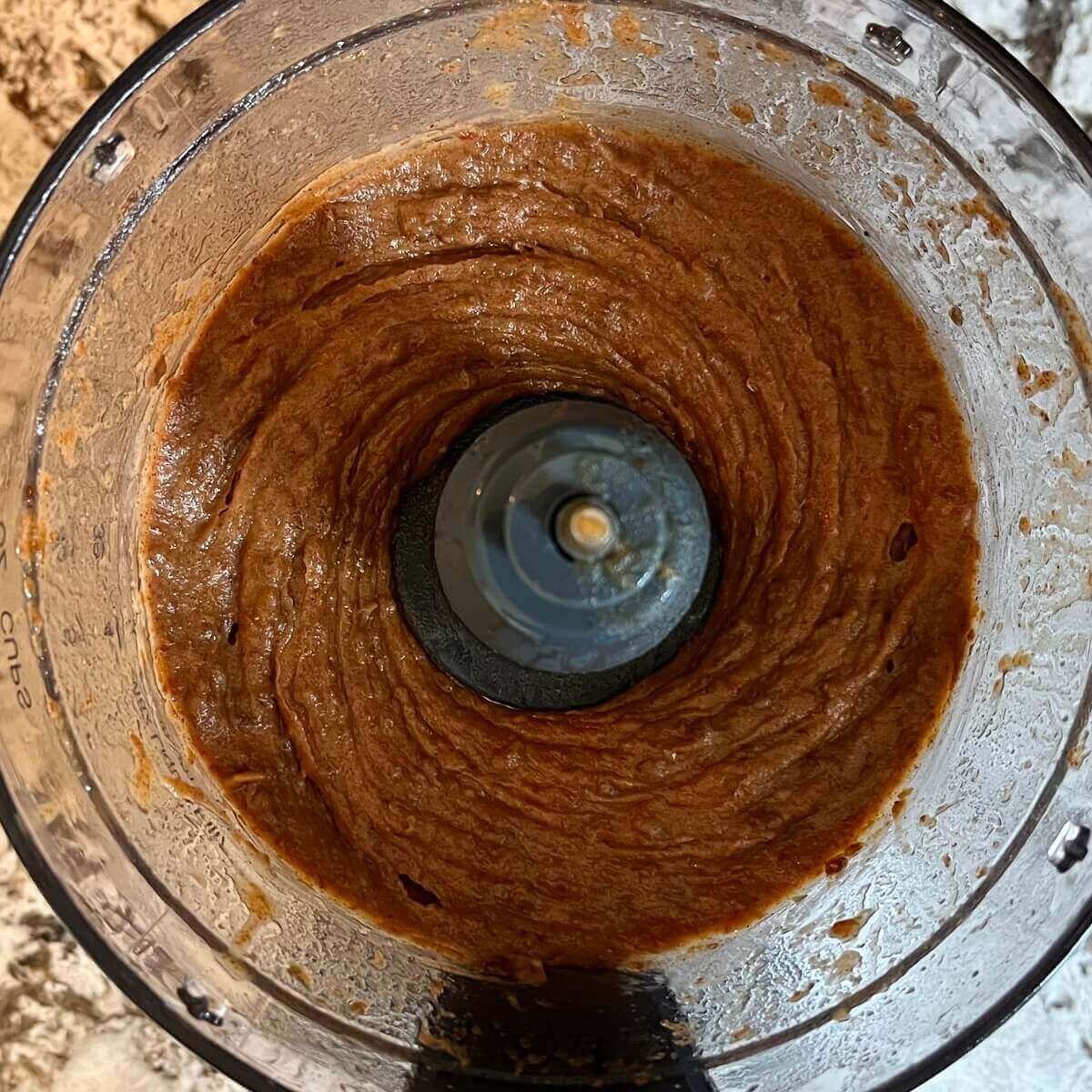 Blended mixture of dates and other ingredients in a food processor.