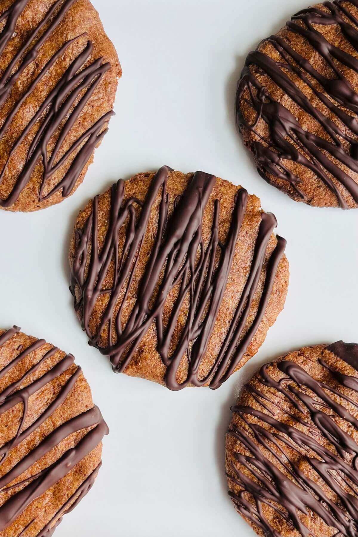 Cookies drizzled with dark chocolate on a platter.