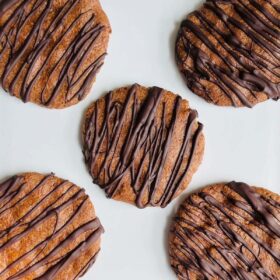 Five flaxseed cookies on a white plate.