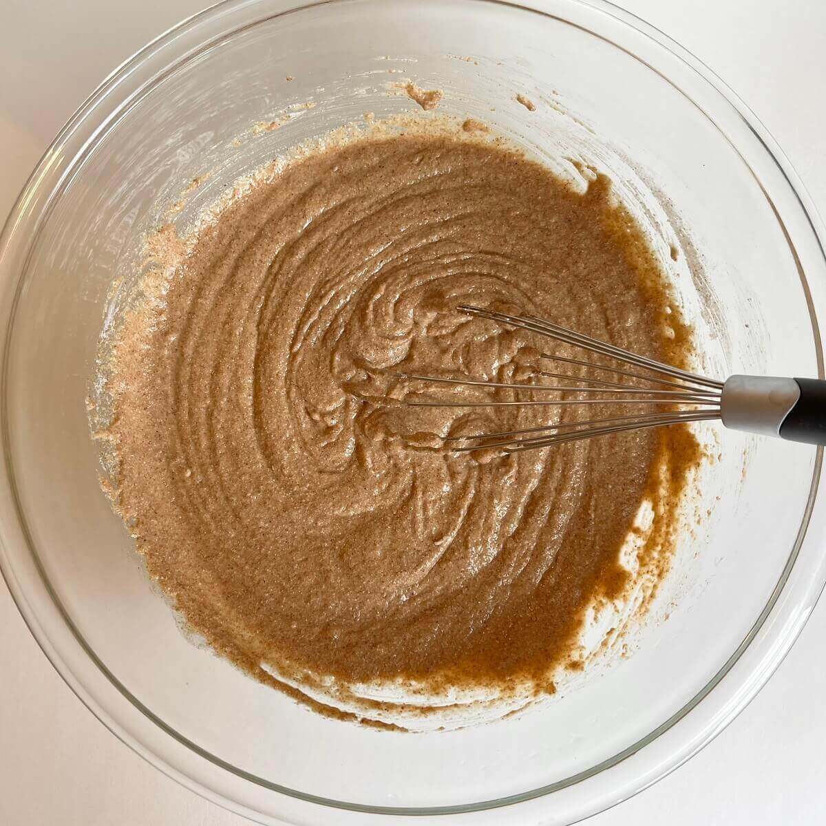 Apple muffin batter in a glass mixing bowl.