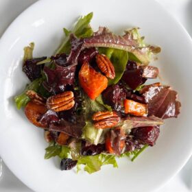 Beetroot and sweet potato salad in a white bowl.