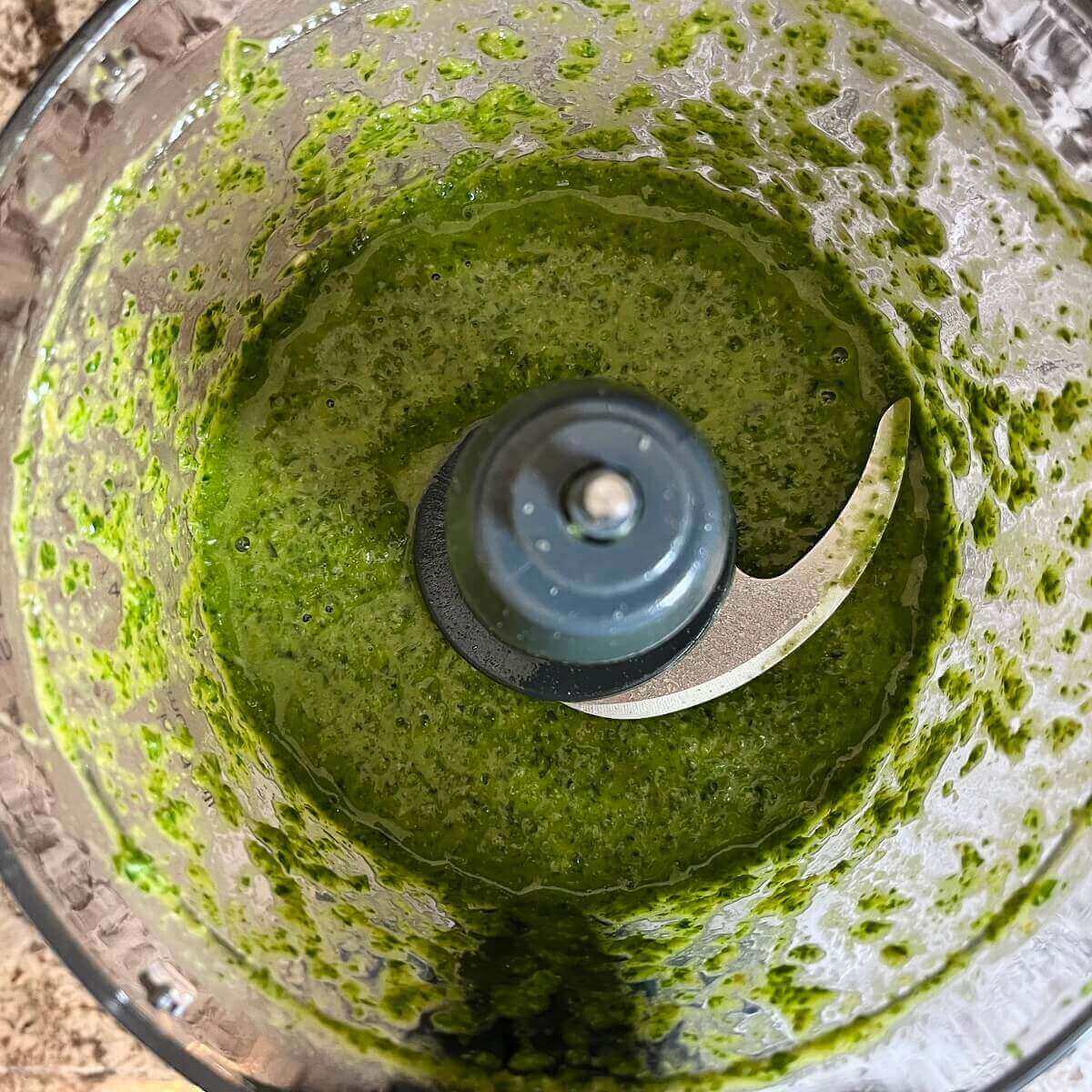 Blended green sauce in a food processor.