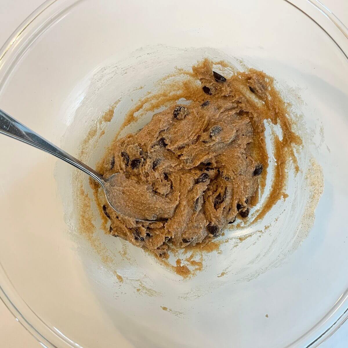 Vegan cookie dough made with coconut oil in a glass mixing bowl.