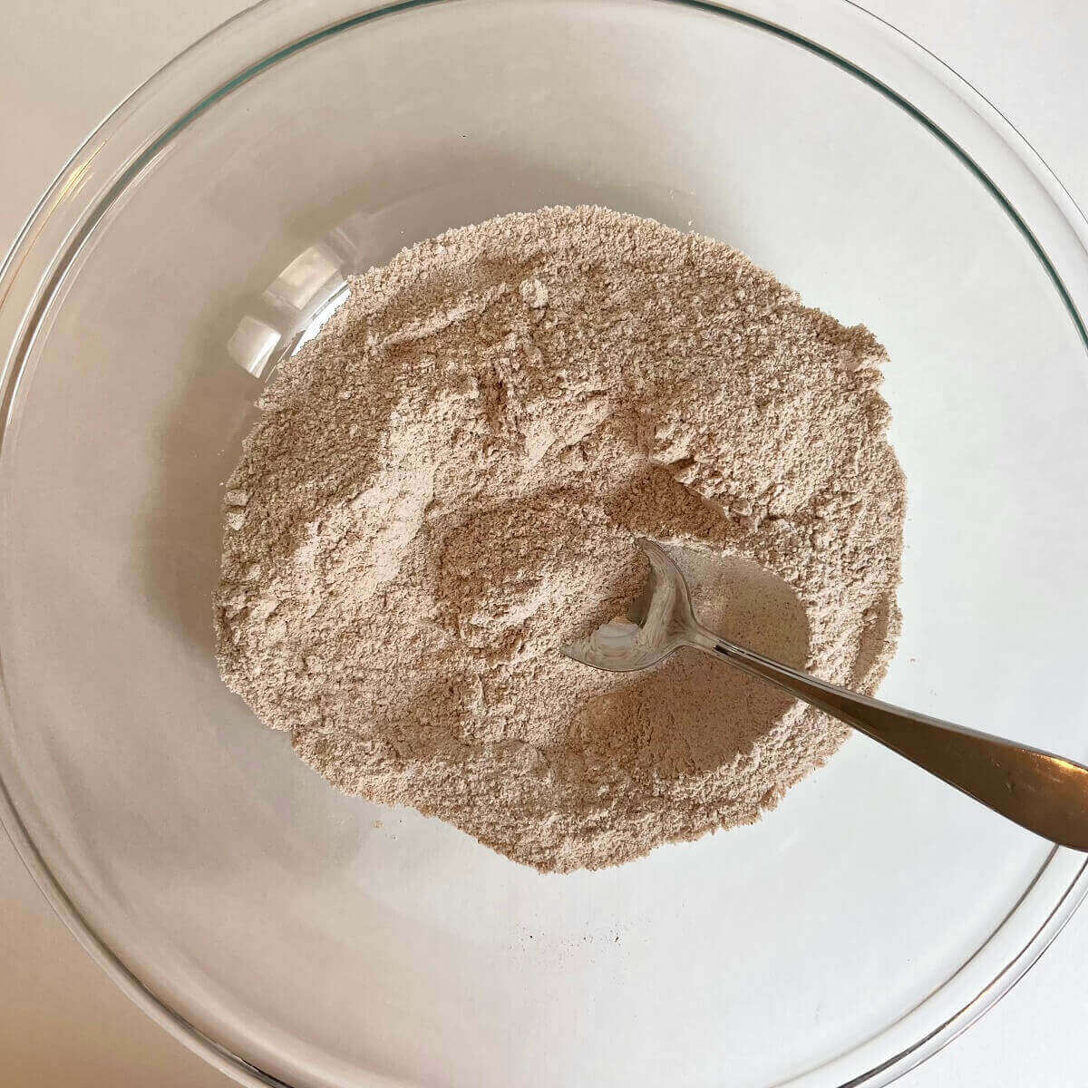 Dry ingredients for muffins in a glass mixing bowl.