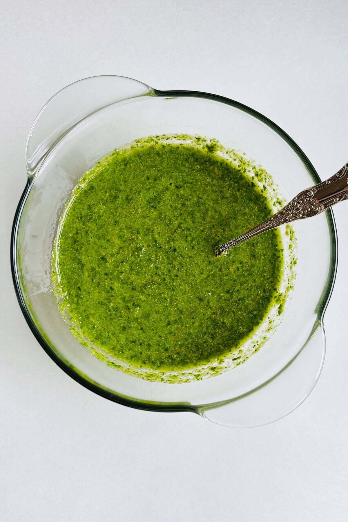 A bowl full of green sauce made with fresh herbs.