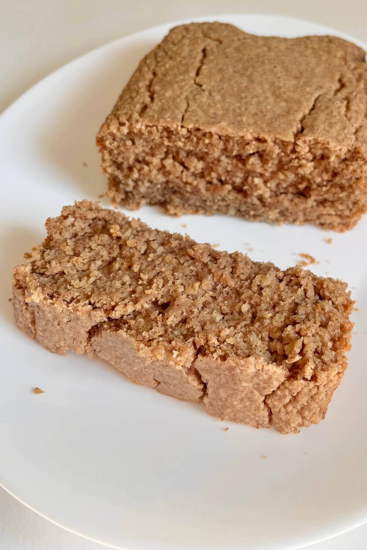 A slice of gluten-free oat cake next to the rest of the loaf.