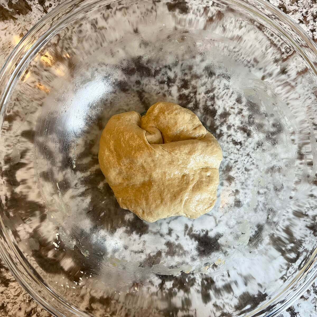 Kneaded dough in a glass bowl.