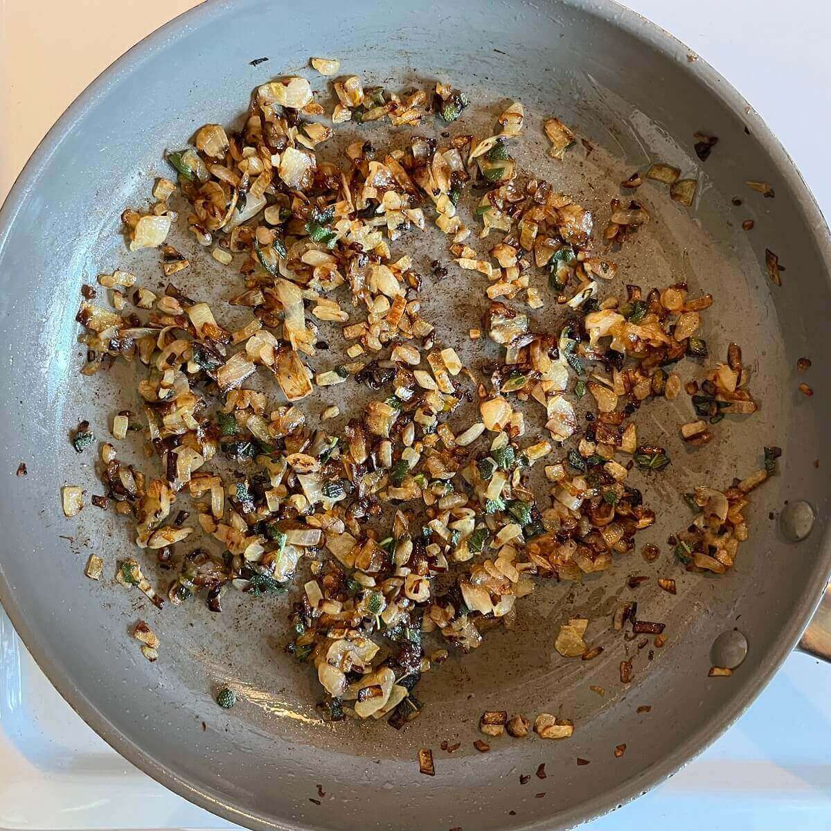 Sauteed onions and sage in a large frying pan.