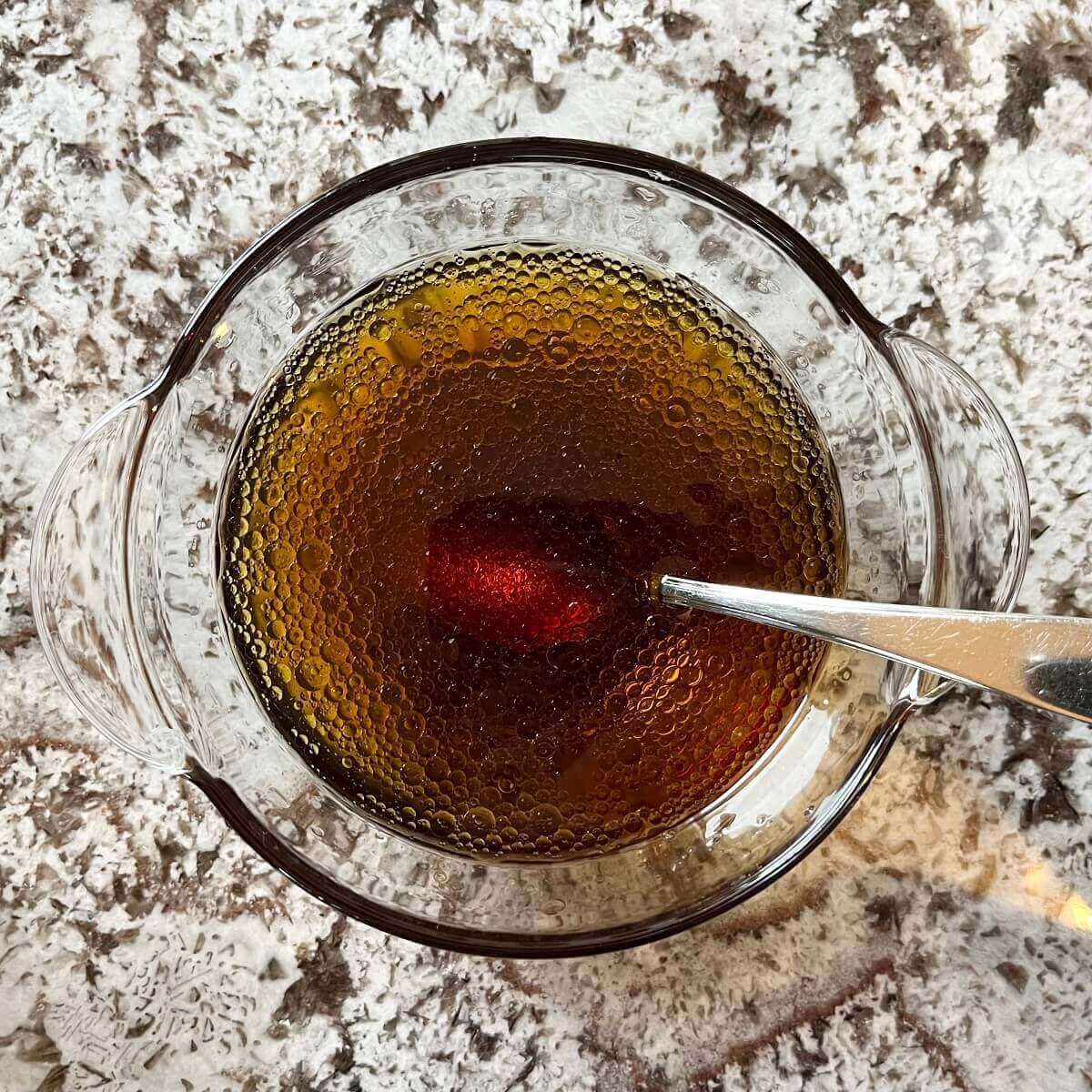 Oil, soy sauce, and water in a glass bowl.