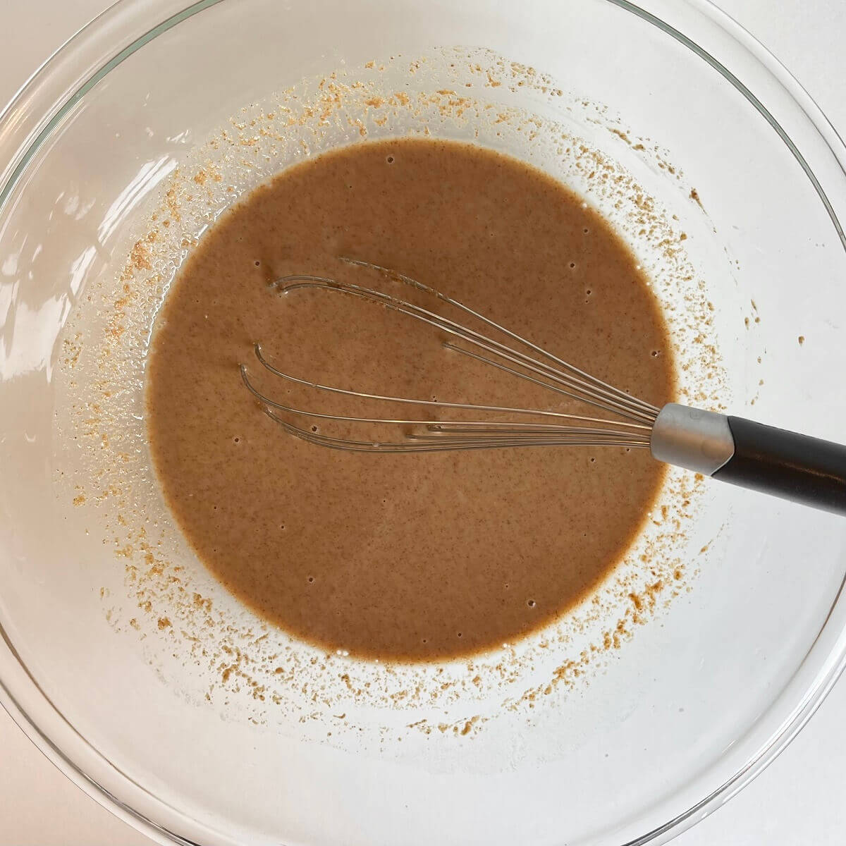 Wet ingredients for muffins in a glass mixing bowl.