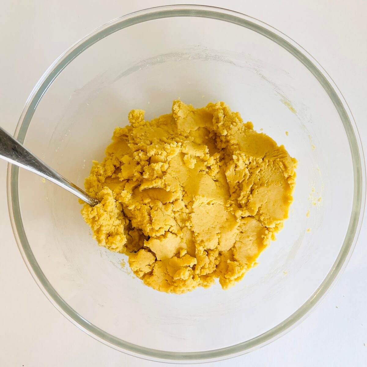 Cornbread cookie dough in a glass mixing bowl.