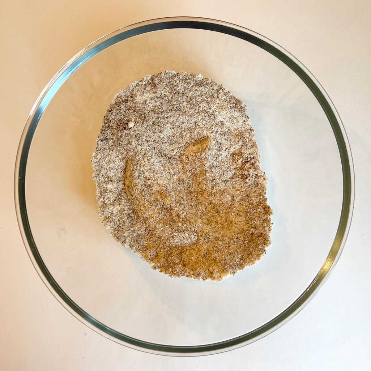 Dry ingredients for donuts in a glass bowl.