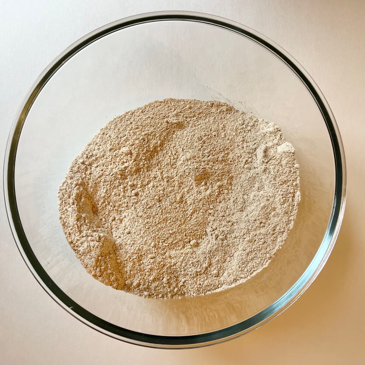 Dry ingredients for banana blueberry muffins in a glass bowl.