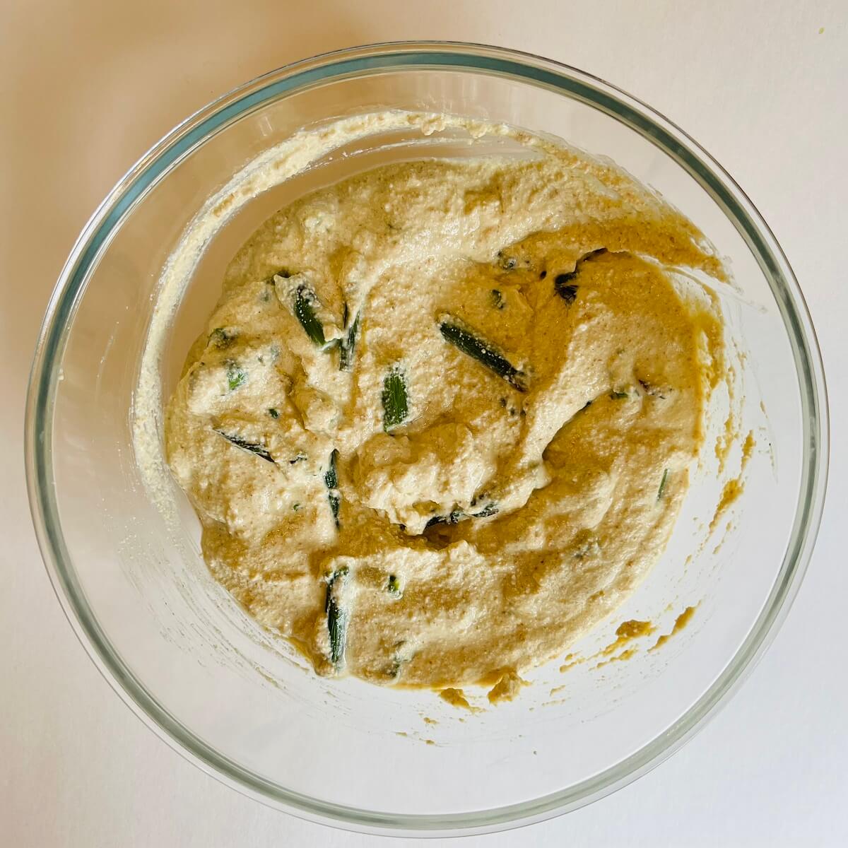 Frittata batter in a glass mixing bowl.