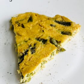 A slice of frittata on a white plate.