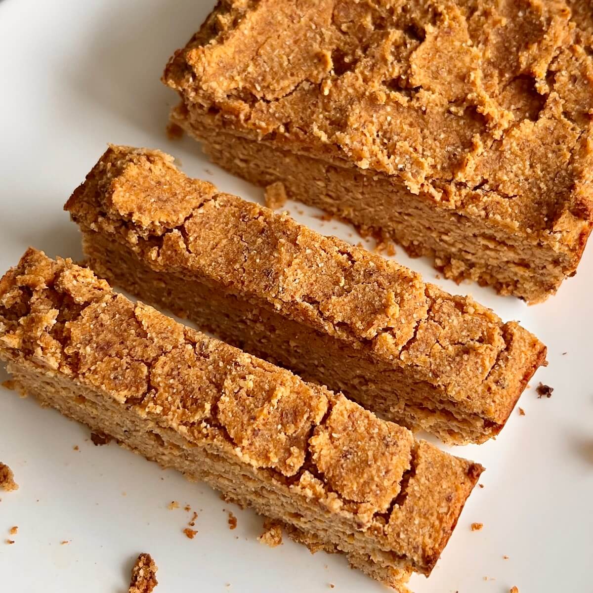 A loaf of gluten free sweet potato bread with two slices cut.