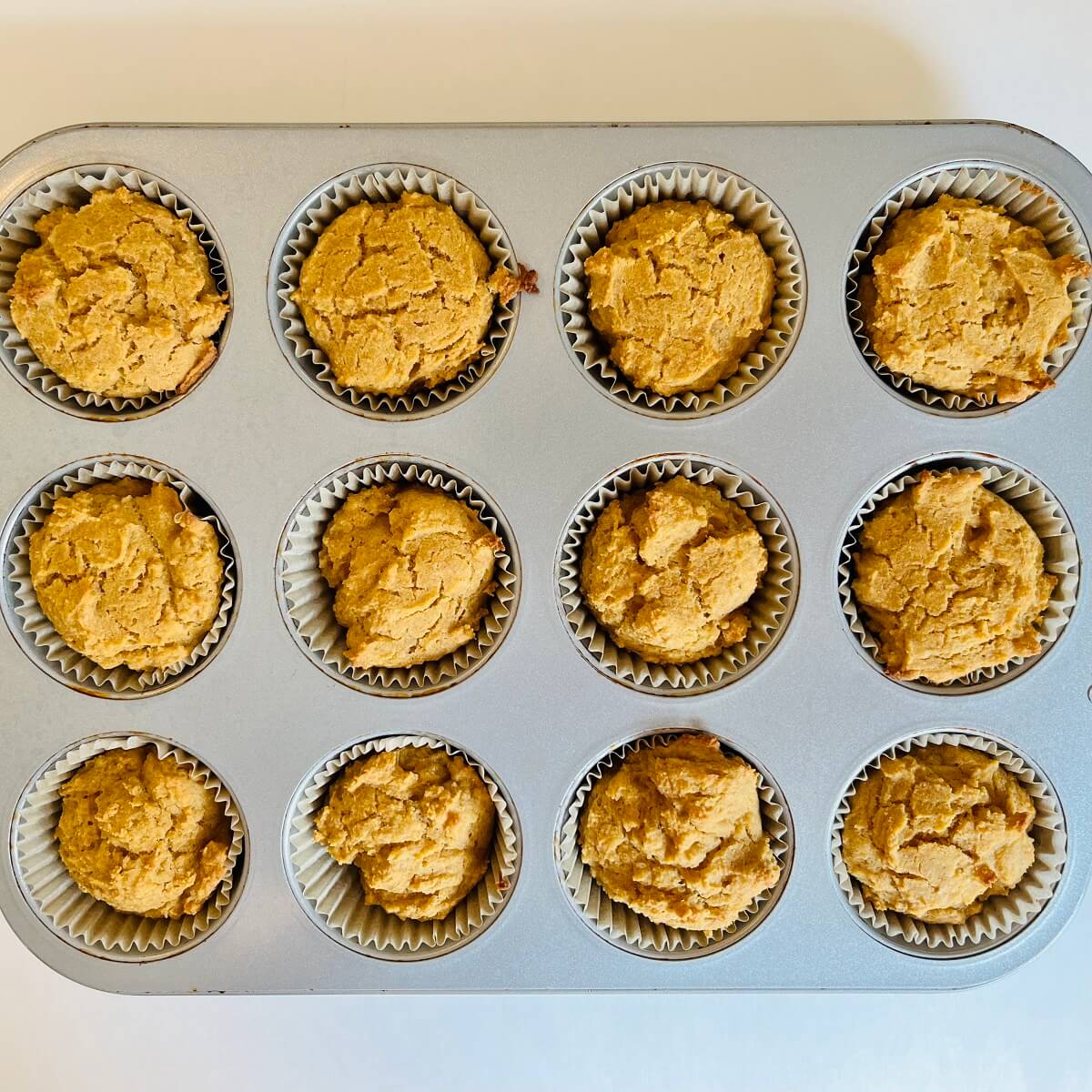 Freshly baked corn muffins in a metal pan.