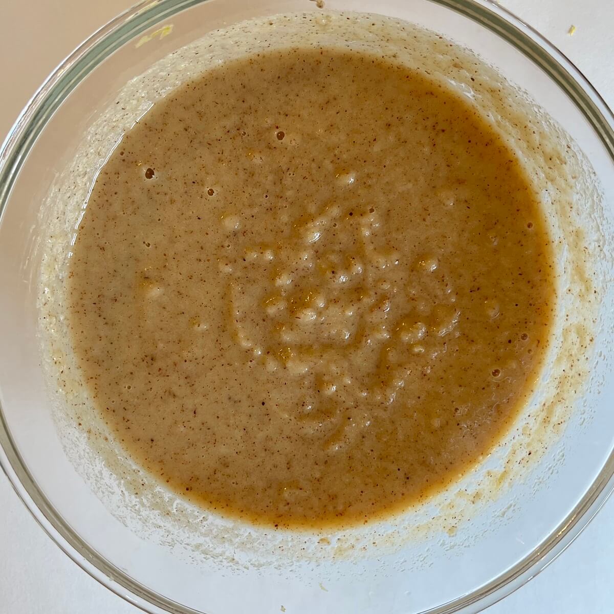 Wet ingredients for lemon cake in a glass mixing bowl.