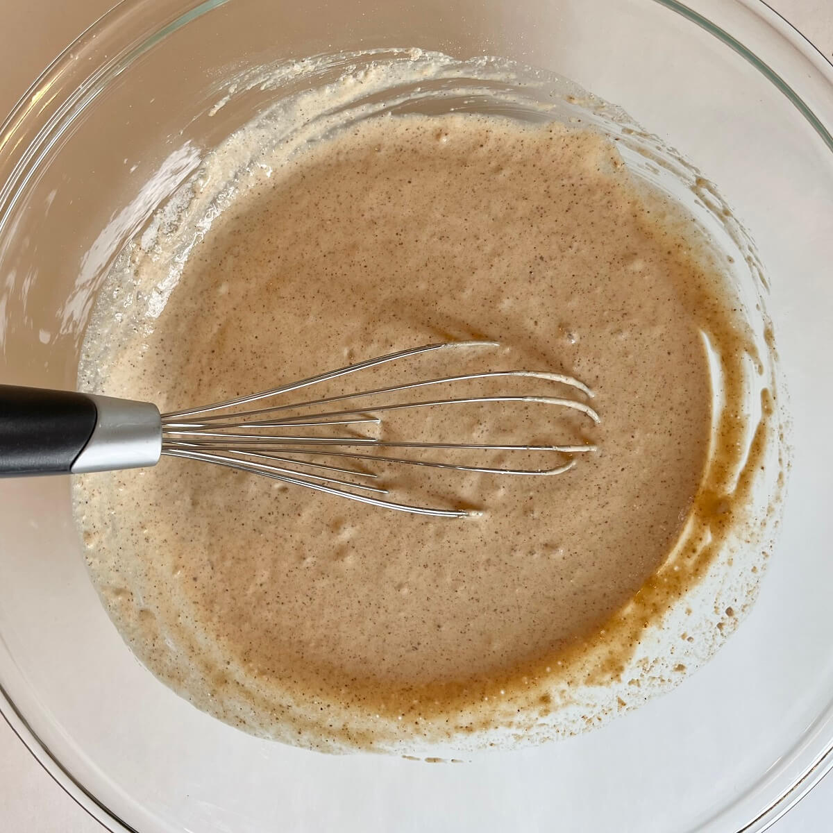 Oat pancake batter in a glass mixing bowl.