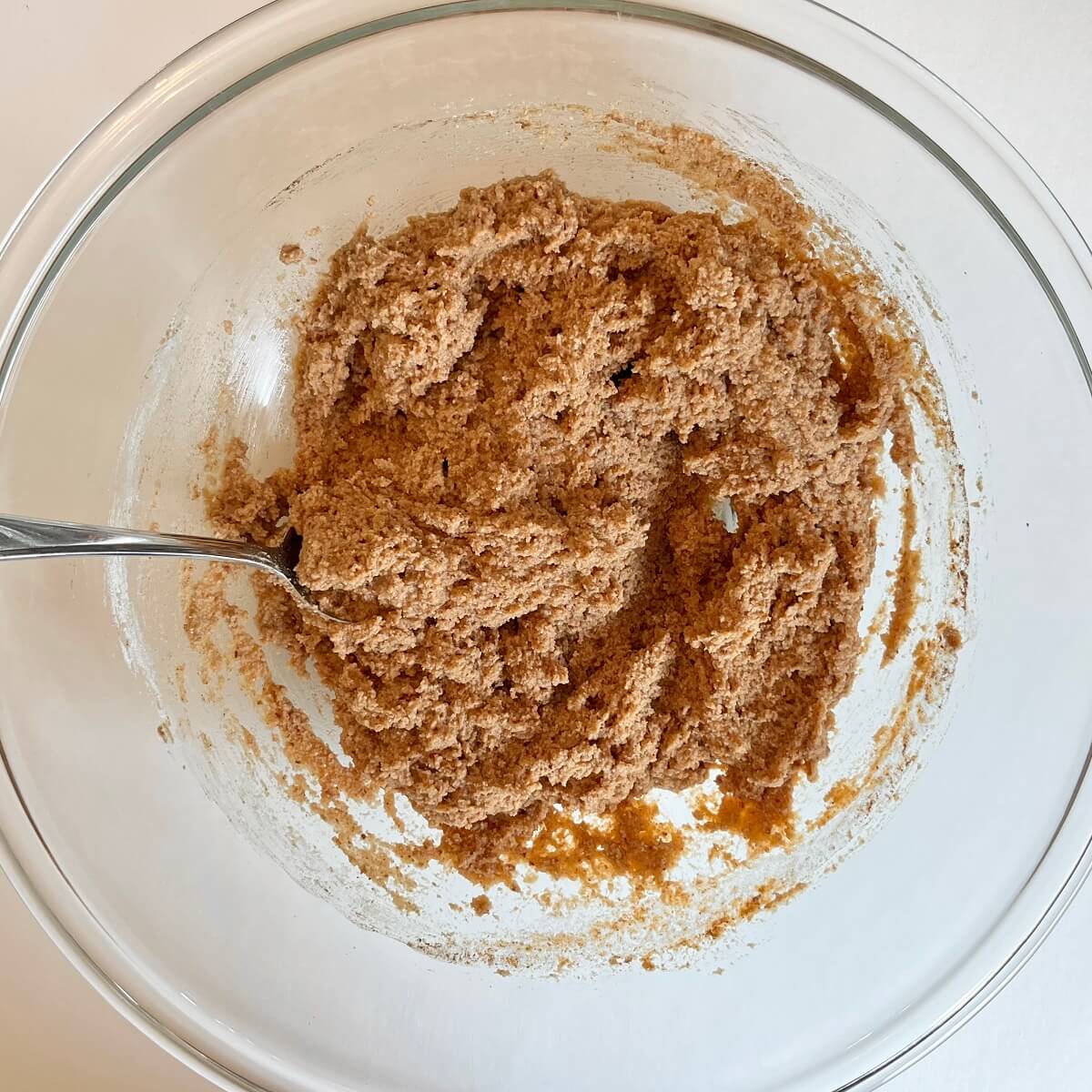 Thick carrot cake batter in a glass bowl.