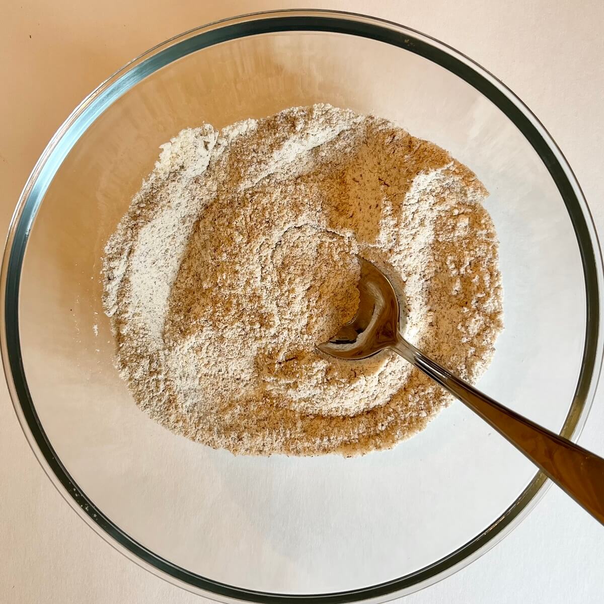 Dry ingredients for pumpkin bread in a glass bowl.