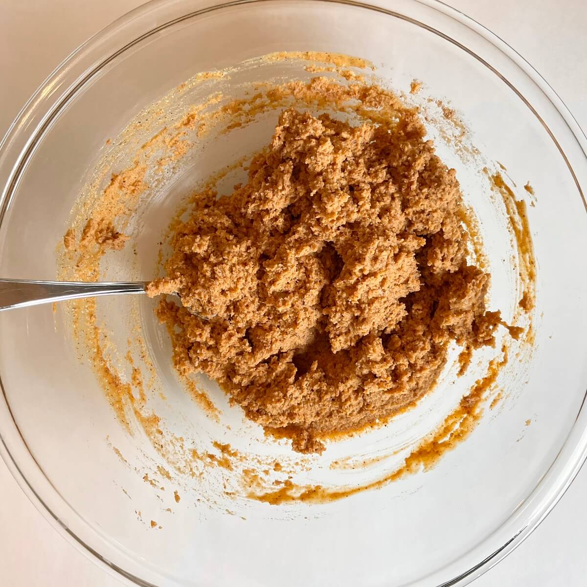 Sweet potato batter in a large glass mixing bowl.