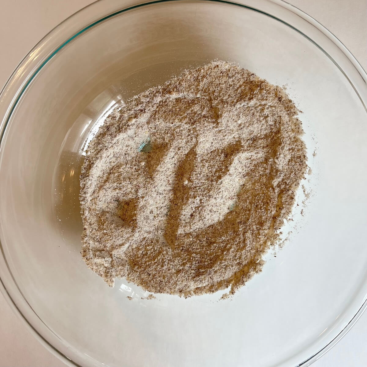 Dry ingredients for sweet potato bread in a glass mixing bowl.