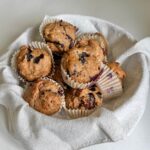 A basket full of vegan blueberry banana muffins.