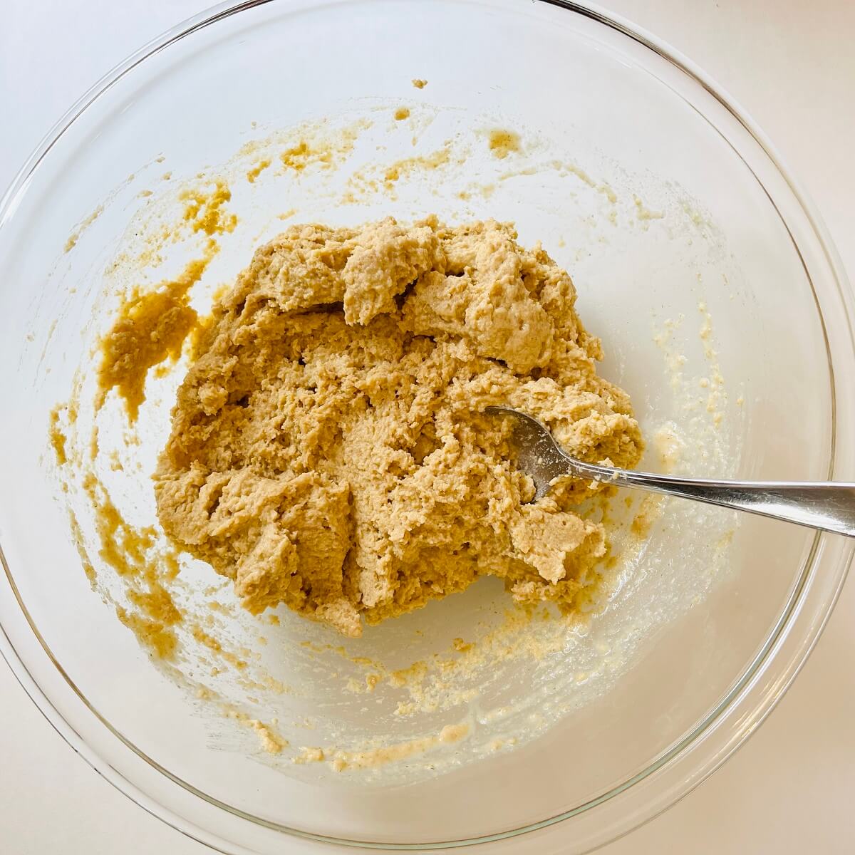 Vegan corn muffin batter in a glass mixing bowl.