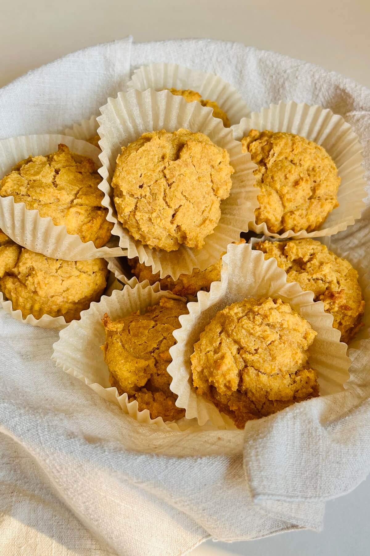 Vegan corn muffins in a basket lined with a linen napkin.