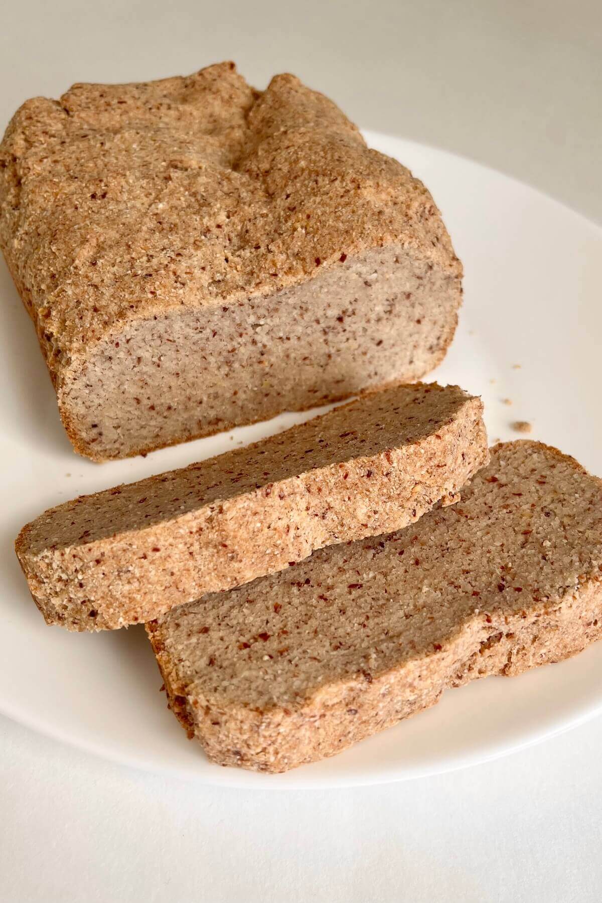 A loaf of vegan low carb bread with two slices cut.