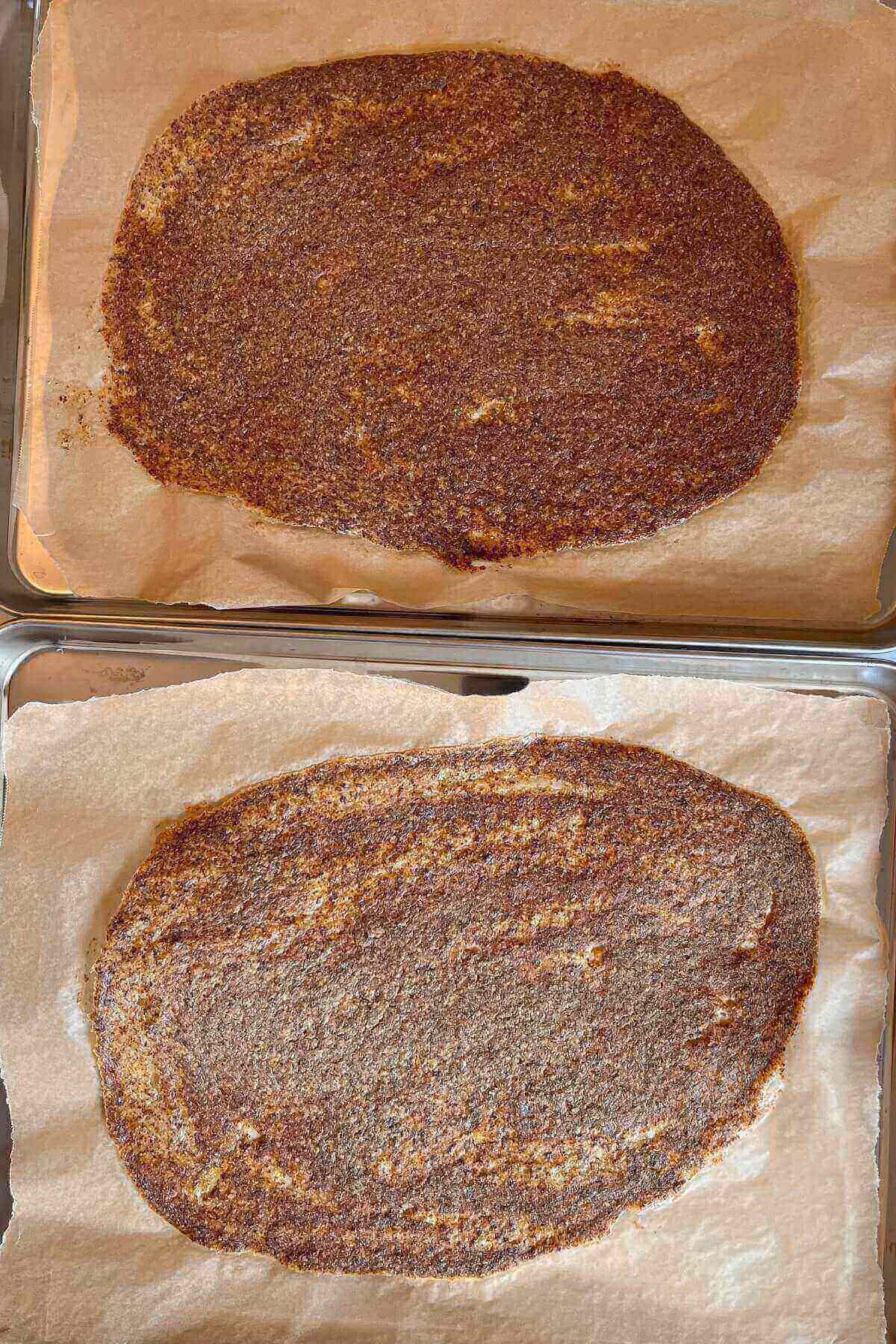Freshly baked crackers on two sheet pans lined with parchment paper.