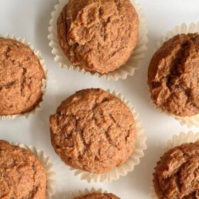 Muffins in paper baking cups on a white plate.