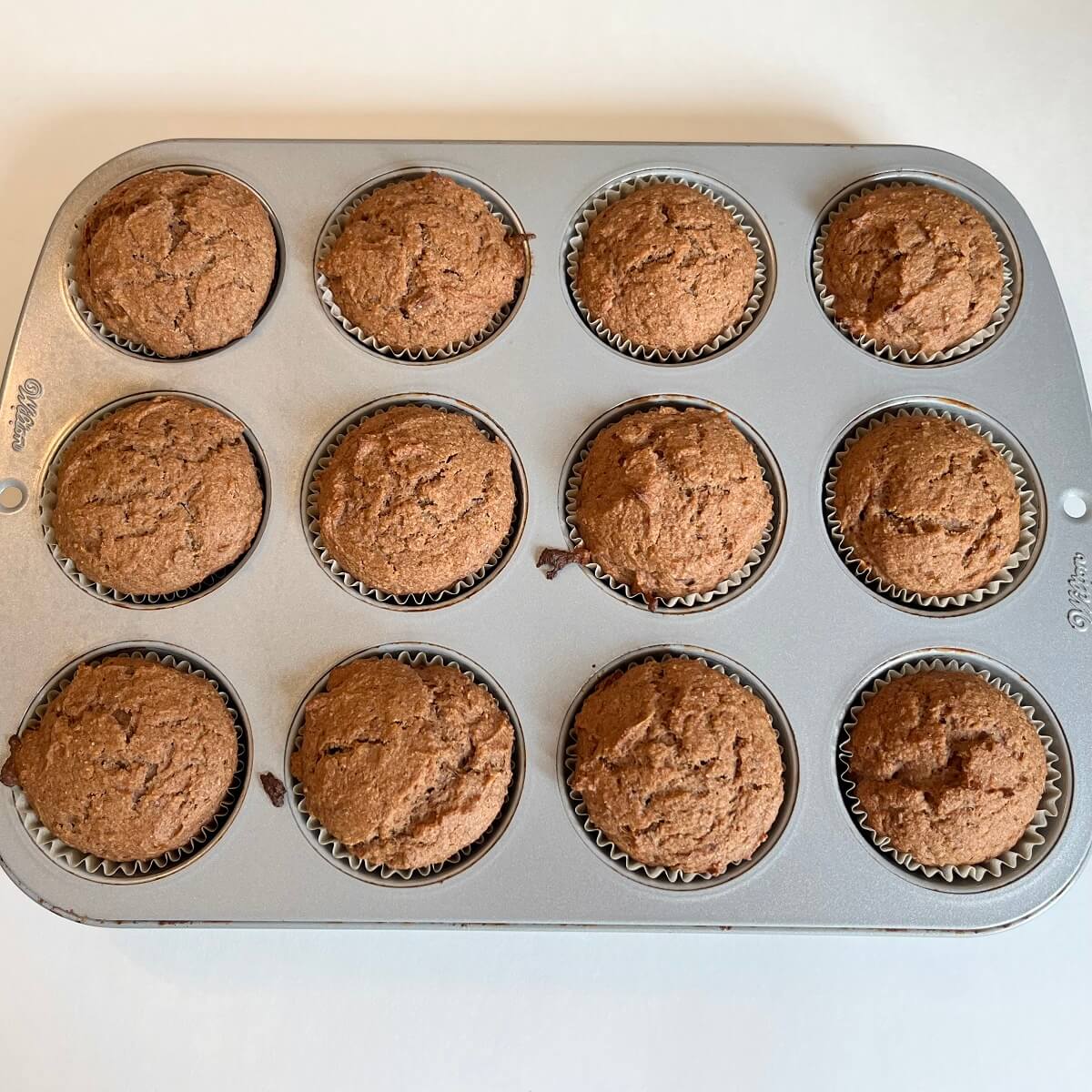 Freshly baked muffins in a metal pan.