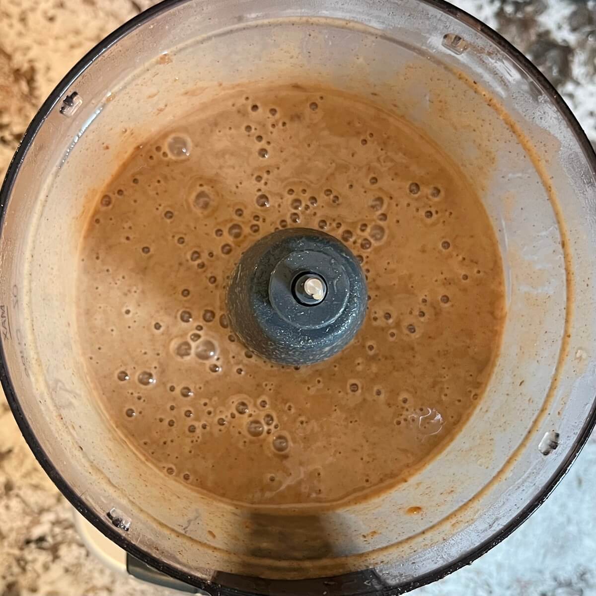 Blended wet ingredients for muffin batter in a food processor.