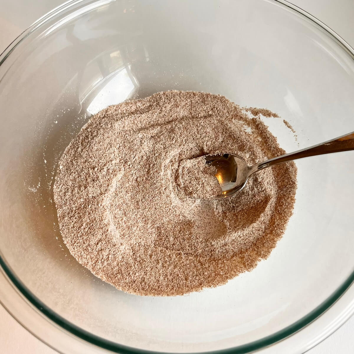 Dry ingredients for pumpkin cookies in a glass bowl.