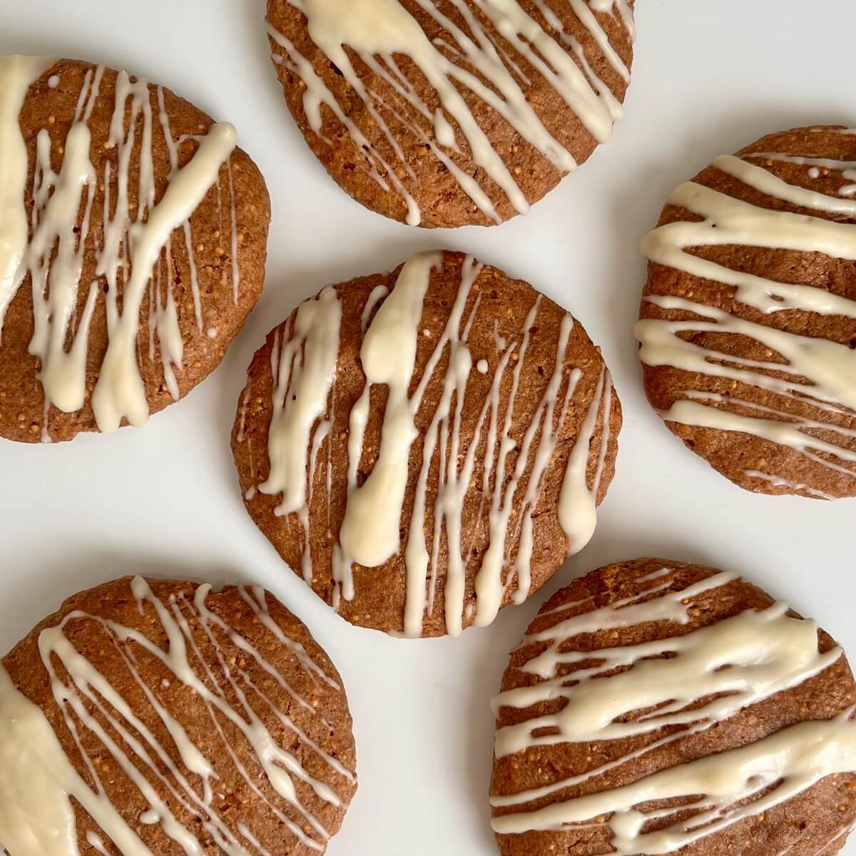 Six dried fig cookies on a white plate.