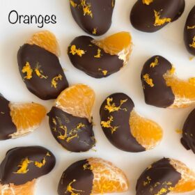 Orange segments dipped in chocolate on a white plate.