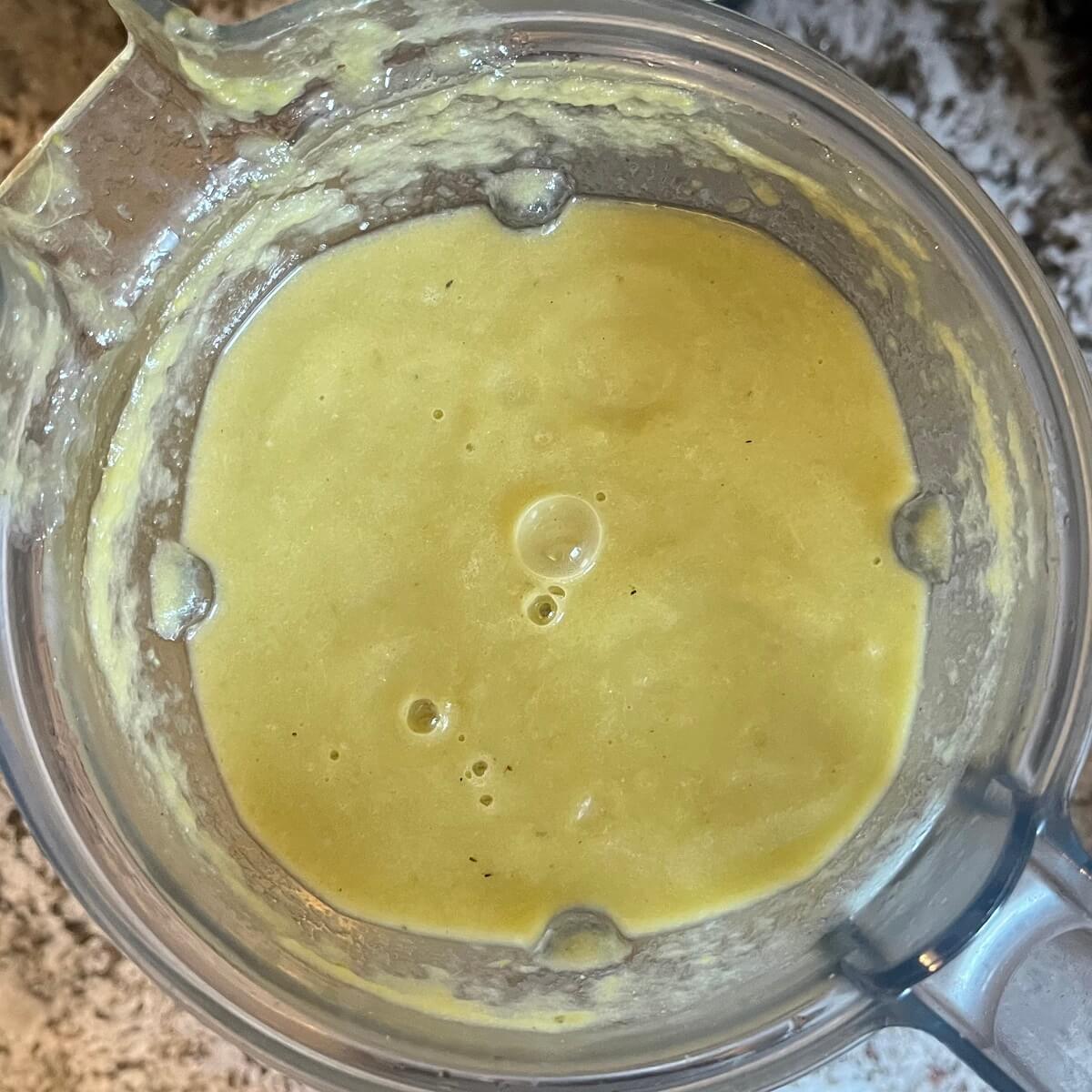 Thick green soup in a blender.