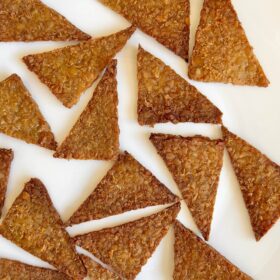 Triangular pieces of crispy tempeh on a white plate.