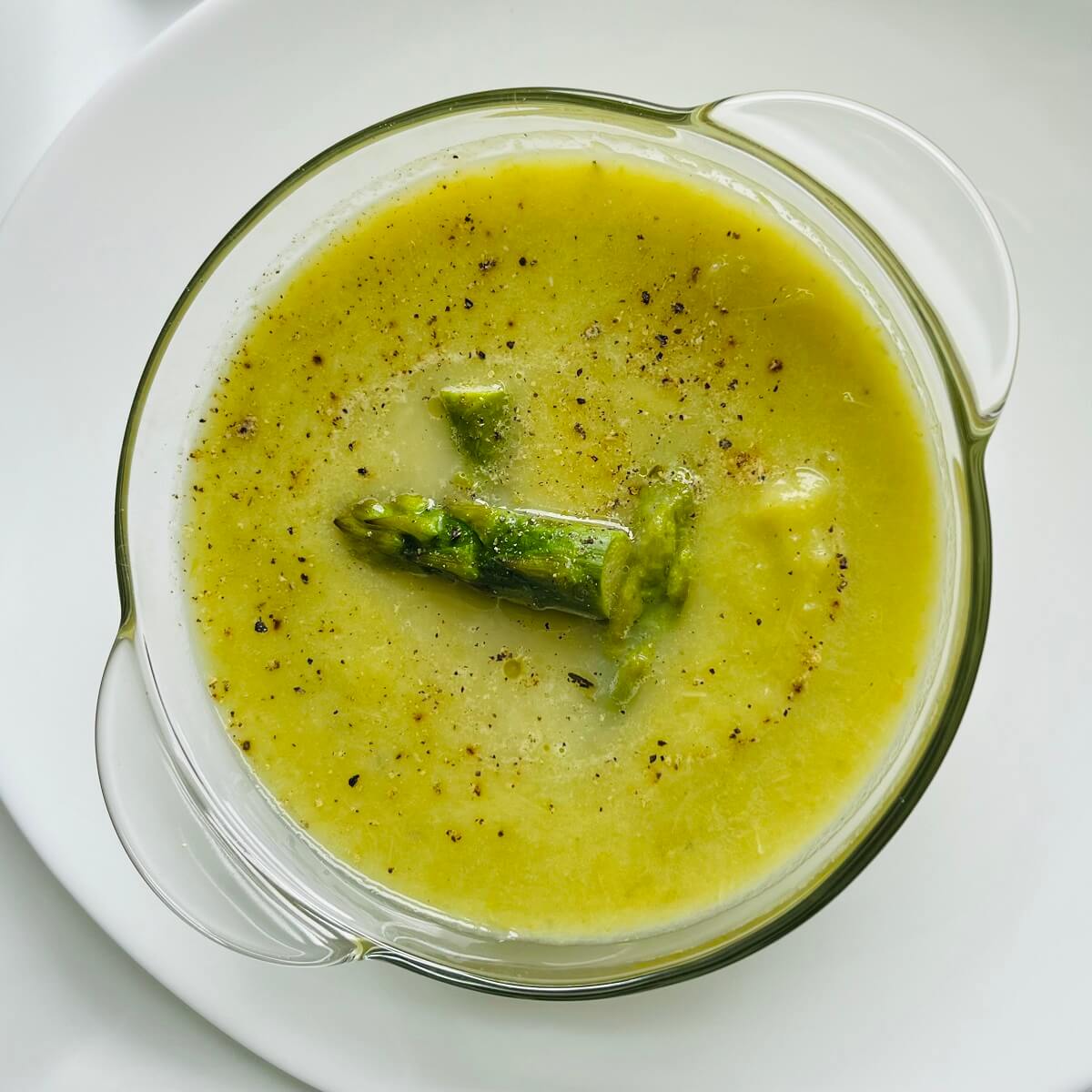 Dairy free asparagus soup in a glass bowl.