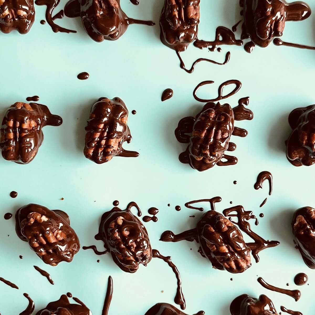 Pecan chocolates on a silicone baking mat.