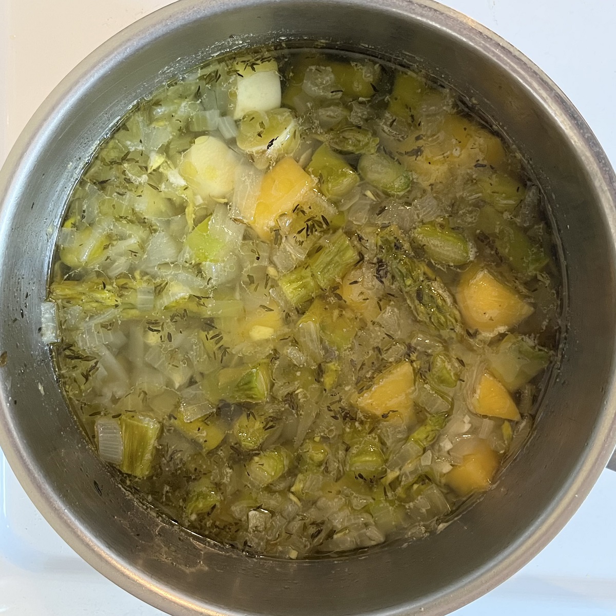 Cooked vegetables and liquid in a pot.